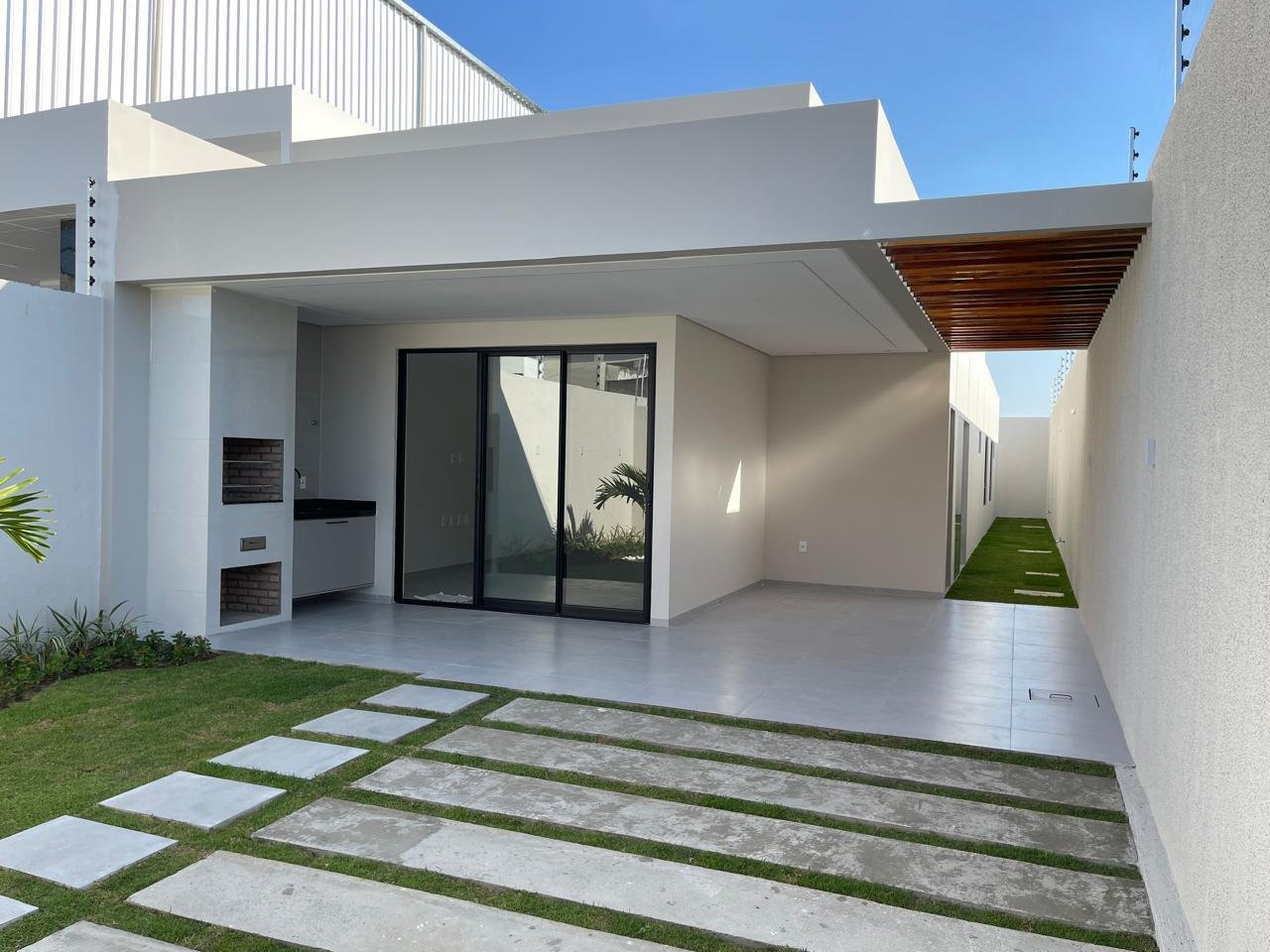 Entrada da Casa Jardins, com jardim e caminho de pedras